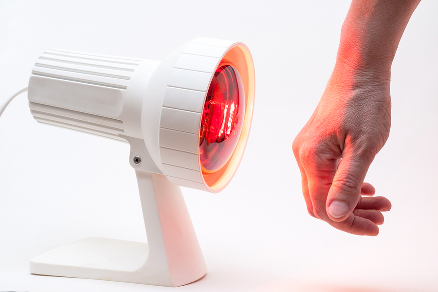Infrarotbehandlung Hand mit Rotlichtlampe